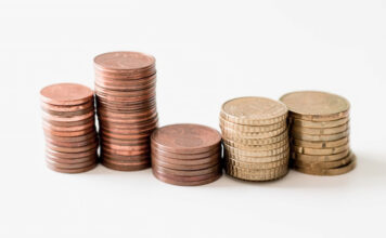 Stacks of copper and gold coins arranged in ascending order on a white background.
